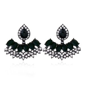 Detail of vintage emerald resin drop earrings with small white diamonds on gunmetal base