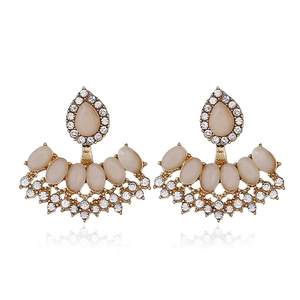 Detailed view of vintage gold earrings with teardrop pearls and pavé rhinestones