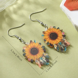 Detalle de pendientes de girasol acrílicos con dimensiones de 5,3 cm de alto por 2,2 cm de ancho