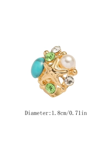 Dettaglio dell'anello a stella marina dorato con pietra turchese e perla, diametro 1,8 cm