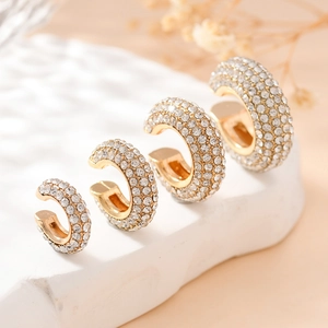Lot de quatre boucles d'oreilles dorées en C serties de zircons blancs sur socle