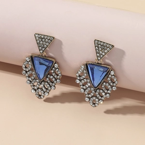 Detail view of vintage triangle drop earrings with blue crystal and gold-toned metalwork