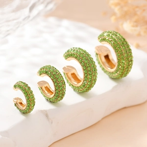 Lot de quatre bagues d'oreilles dorées en forme de C avec cristaux verts de différentes tailles