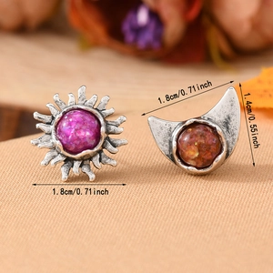 Macro shot of vintage sun and moon earrings with purple and orange inlaid stones