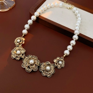 Detail of vintage French court style necklace with gold floral charms and white pearls