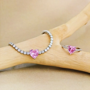 Pink heart zirconia jewelry set with tennis bracelet and ring on a wood branch