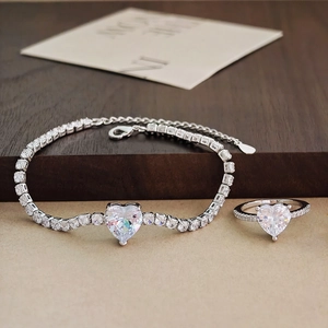 Sparkling heart-shaped zircon jewelry set with tennis bracelet and ring on wood surface
