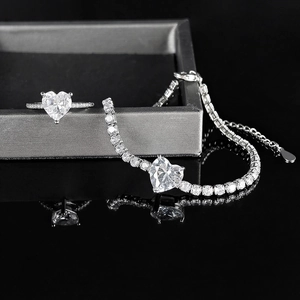 Macro view of heart-shaped zircon jewelry set featuring ring and bracelet in silver finish