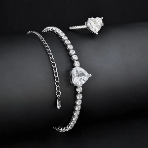 Close-up of heart-shaped zircon ring and tennis bracelet on black background