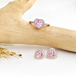 Detail von rosa herzförmigem Zirkonia-Schmuckset auf Holz mit Roségold-Halo-Fassung