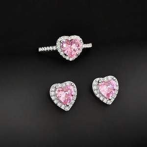 Makroaufnahme eines rosa herzförmigen Zirkonia-Schmucksets mit Halo-Diamantfassung