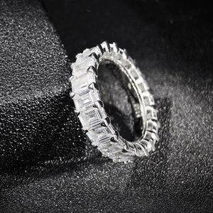 Détail macro d'une bague éternité en zircone taille émeraude sur fond noir mat