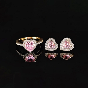 Detail von goldenem Schmuckset mit rosa Herz-Zirkonia-Ring und passenden Ohrsteckern