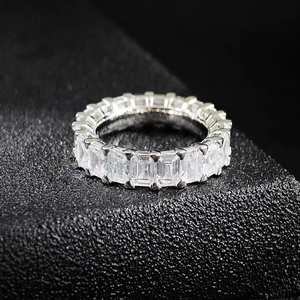 Détail macro de pierres zircones taille émeraude serties sur une bague éternité en argent
