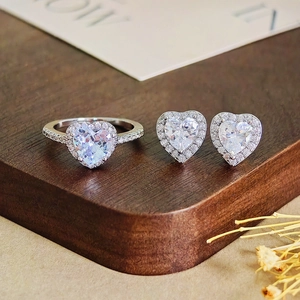 Detailansicht von Herz-Zirkonia Ring und Ohrringen Set auf einem Holzdisplay