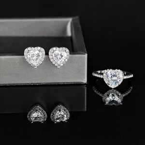Detail von herzförmigem Zirkon Ring und Ohrringen Set auf schwarzem Reflexionsständer