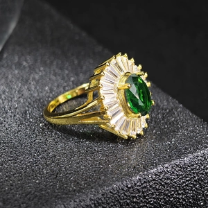 Macro view of emerald green zircon ring with sunburst halo and gold plated band