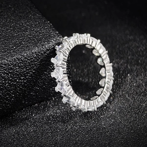 Elegant silver eternity ring with heart-cut crystals on a textured black background