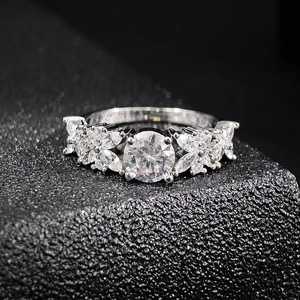 Macro shot of silver floral ring with marquise zircon stones on black background