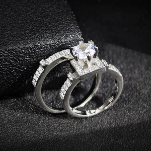 Exquisito conjunto de anillos halo plateados con piedra redonda y bandas de pavé de circonitas