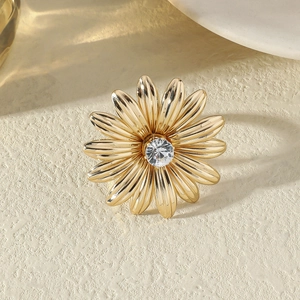 Vue macro d'une bague fleur dorée ornée d'une pierre centrale en zircone cubique