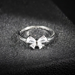 Gros plan d'une bague papillon en argent ornée de quatre pierres de zircone cubique étincelantes