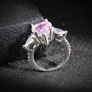 Elegante anillo con piedra ovalada rosa, piedras laterales pera y banda de plata