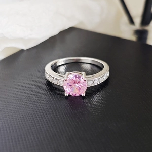 Exquisite silver-colored ring featuring a round pink zircon center stone with side accents
