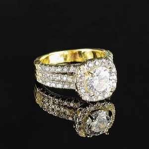 Detalle de anillo halo dorado con circón redondo y engaste de pavé de diamantes