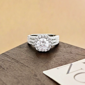 Anillo halo elegante con circonita redonda y banda de triple pavé sobre madera