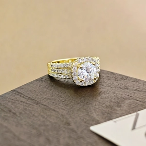 Vista detallada de un anillo de oro con circón redondo, diseño halo y pavé brillante