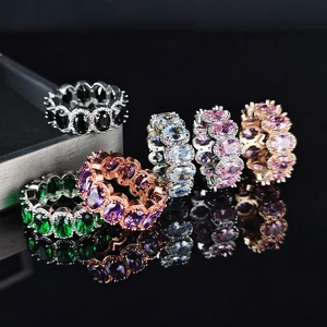 Set di anelli eternity con zirconi ovali colorati su base nera con effetto specchio