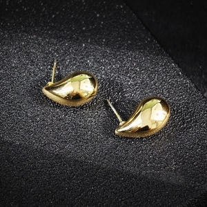 Makroaufnahme polierter goldener Tropfenohrringe mit elegantem metallischem Glanz