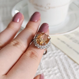 Luxurious oval champagne zircon ring with white pave crystals in elegant silver setting