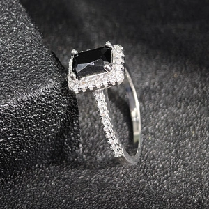 Eleganter Ring mit schwarzem quadratischem Edelstein und glitzernder Halo-Fassung aus Silber