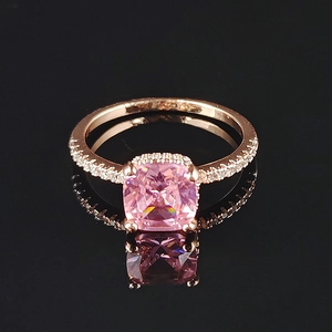 Luxury rose gold ring with cushion-cut pink gemstone and pavé-set zircons on black background
