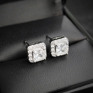 Elegantes pendientes de circonita cuadrada plateada con halo sobre fondo de cuero negro