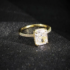 Elegant gold ring with a large rectangular cut gemstone and side diamond accents