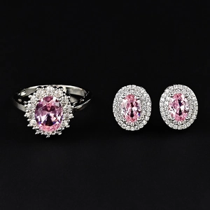 Elegantes Schmuckset mit rosa ovalem Edelsteinring und Halo-Ohrsteckern auf schwarzem Grund