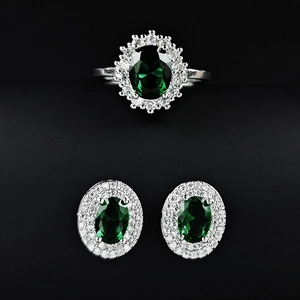 Detailaufnahme von Smaragdgrünem Ring- und Ohrringset mit Halo-Diamant-Design