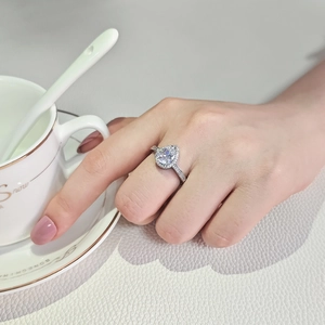Elegante anello d'argento con halo a forma di pera e fascia pavé indossato a mano