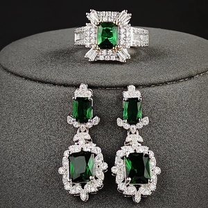 Classic silver jewelry set with emerald-cut green gemstones and sparkling accent diamonds