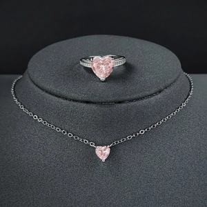 Elegant jewelry set with pink heart gemstone ring and necklace on grey display stand