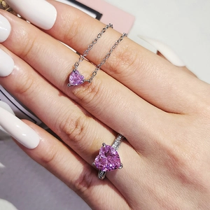 Pink heart-shaped zircon necklace and ring set with side-set diamonds on silver-tone band