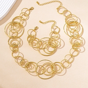 Detail of gold geometric circle necklace and bracelet set with textured metal rings