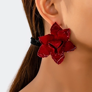 Close-up of elegant red 3D flower stud earrings with glossy textured layered petals