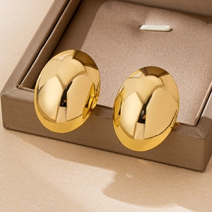 Makroaufnahme großer ovaler goldener Ohrstecker mit polierter Spiegeloberfläche auf Box