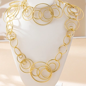 Detail of layered gold geometric circles necklace with textured surface on a bust stand