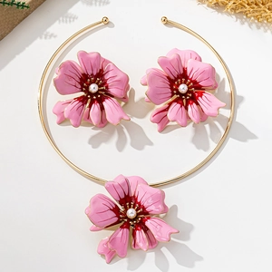 Detailed view of pink floral enamel jewelry set with pearls and gold geometric necklace