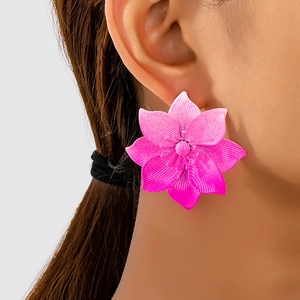 Close-up of pink gradient floral stud earring worn on ear with detailed petals